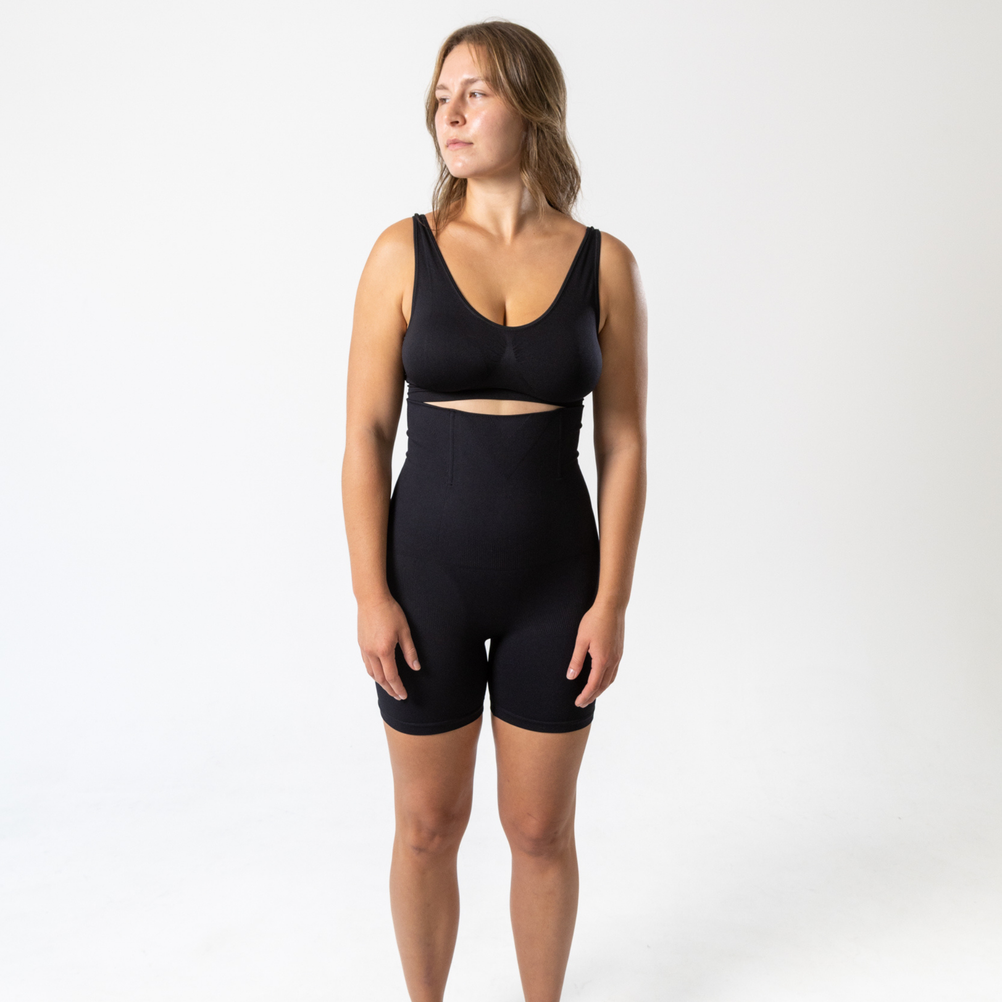 Full-length front view of woman wearing black KORFORM™ high-waisted compression shorts