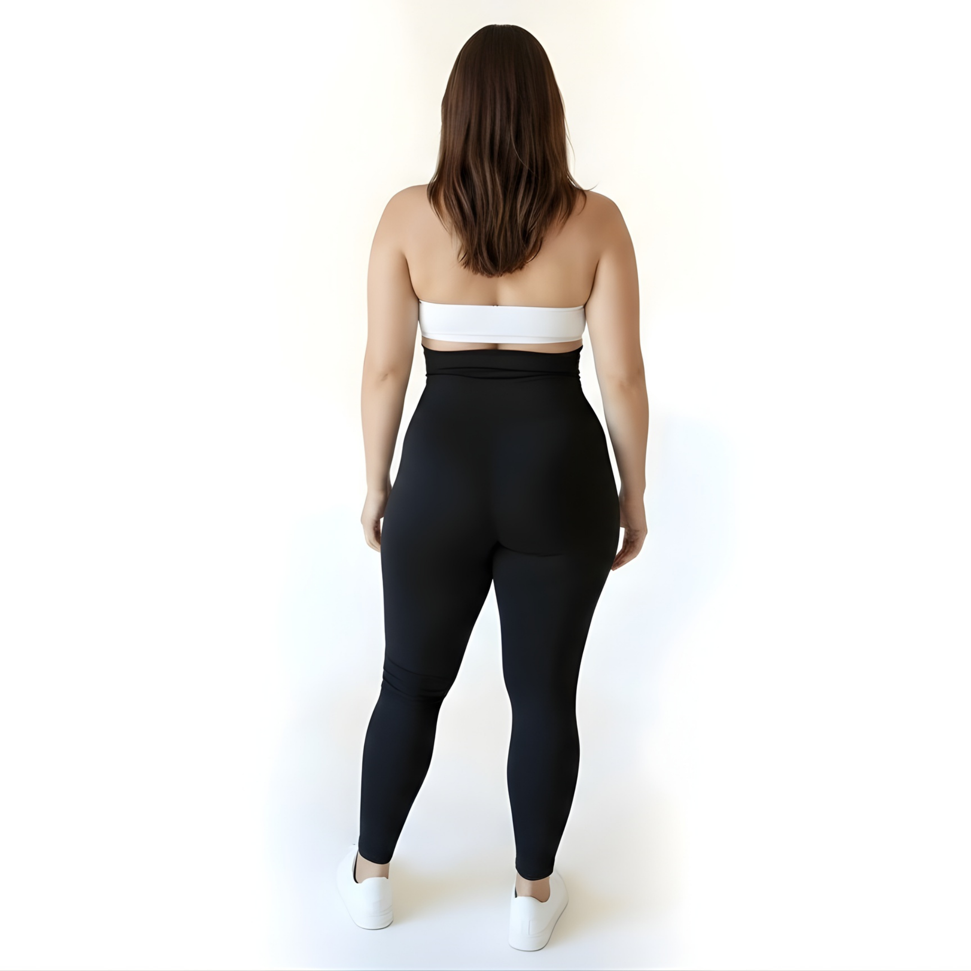Back view of a woman wearing high-waisted black compression leggings and a white sports bra, highlighting lift, coverage, and seamless support — KORFORM activewear.